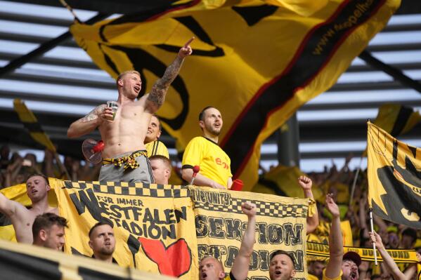 Borussia Dortmund fans cheer during the German Bundesliga soccer match between FC Augsburg and Borussia Dortmund at the WWK Arena in Augsburg, Germany, Sunday, May 21, 2023. (AP Photo/Matthias Schrader)