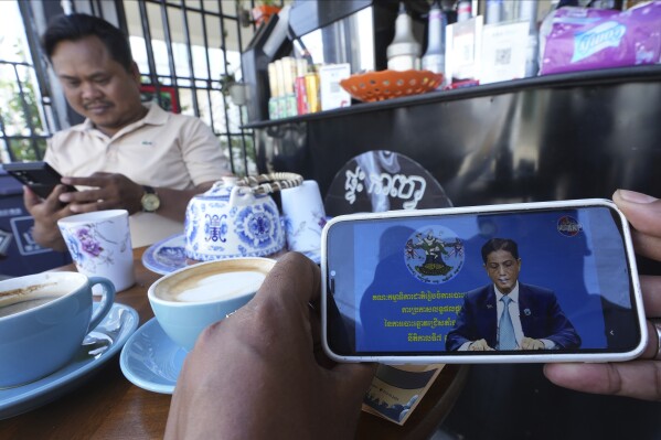 A man watches his mobile phone of broadcasting the election result by the National Election Committee (NEC), at a coffee shop outside Phnom Penh, Cambodia, Saturday, Aug. 5, 2023. Cambodia's electoral body on Saturday announced its final result that see ruling party of long-serving Prime Minister Hun Sen has won a landslide victory from last month election, securing another mandate for the next five years. (AP Photo/Heng Sinith)