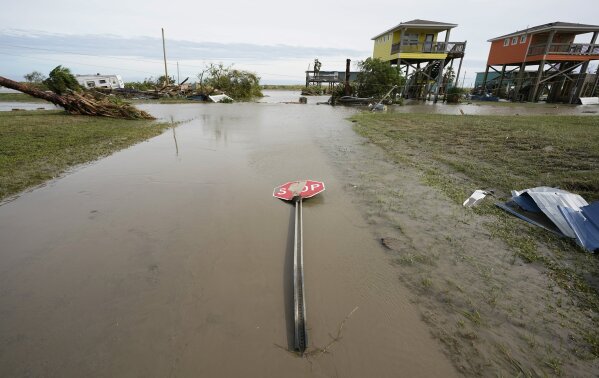A stop sign lies on a muddy street left behind in the wake of Hurricane Laura, Thursday, Aug. 27, 2020, in Holly Beach, La. (AP Photo/Eric Gay)