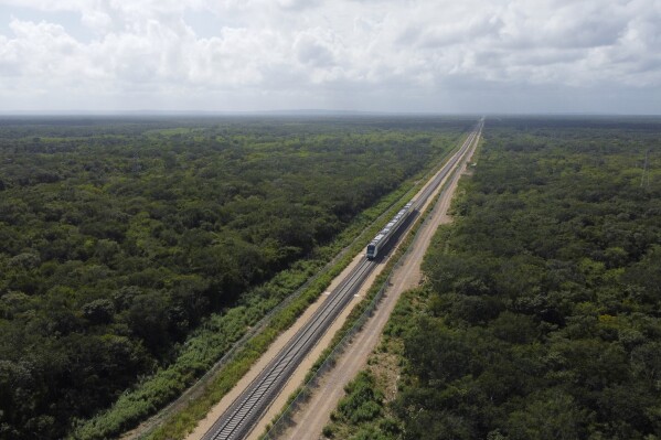 FILE - An inaugural train travels on the Maya Train rail route with President Andrés Manuel López Obrador on board, near Chochola, Quintana Roo State, Mexico, Dec. 15, 2023. The Mexican government blamed a contractor Tuesday, April 2, 2024, for a loose railway fitting that caused a train car to derail on the Maya Train rail route. (AP Photo/Martin Zetina, File)