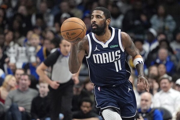 Dallas Mavericks guard Kyrie Irving dribbles the ball during the second half of an NBA basketball game against the Golden State Warriors in Dallas, Wednesday, Feb. 12, 2025. (AP Photo/LM Otero)