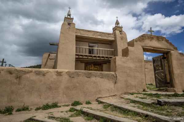 An exterior view of the San Jose de Gracia Catholic Church, built in 1760, in Las Trampas, New Mexico, Friday, April 14, 2023. Threatened by depopulation, dwindling congregations and fading traditions, some faithful are fighting to save their historic adobe churches and the uniquely New Mexican way of life they represent. (AP Photo/Roberto E. Rosales)