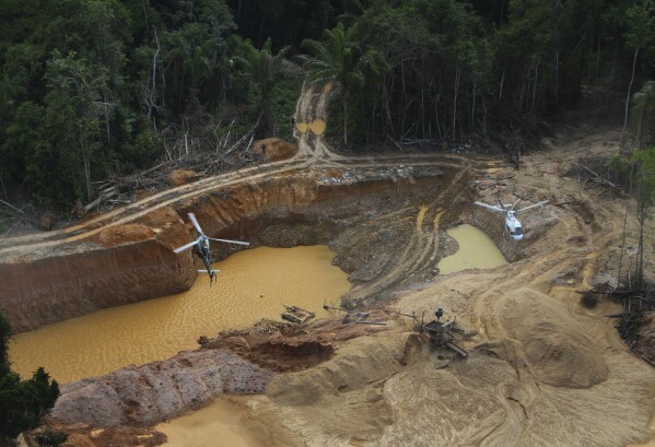 FILE - A Brazil Environmental Agency helicopter flies over an illegal mining camp during an operation to try to contain illegal mining in Yanomami Indigenous territory, Roraima state, Brazil, Feb. 11, 2023. Rio de Janeiro’s Salgueiro samba school, that paid tribute to the Yanomami Indigenous group in the Carnival parade at the Sambrodome on Sunday, Feb. 11, 2024, is seeking to draw attention to the devastating effects brought by illegal mining inside Yanomami territory, including widespread river contamination, famine and disease. (AP Photo/Edmar Barros, File)