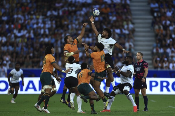 Fiji's Isoa Nasilasila and Australia's Will Skelton challenge for the ball during the Rugby World Cup Pool C match between Australia and Fiji at the Stade Geoffroy Guichard in Saint-Etienne, France, Sunday, Sept. 17, 2023. (AP Photo/Aurelien Morissard)