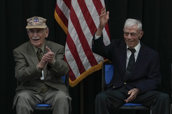 US World War II veterans Harry Moyer, right, gestures next to his compatriot Mel McMullen during a ceremony in honor of Flying Tigers held at the U.S. Embassy in Beijing, Monday, Oct. 30, 2023. China has feted two American veterans of World War II as Beijing and Washington look to past collaboration for inspiration to deal with today's strained ties. Mel McMullen, who is in his late 90s, and Harry Moyer, who turned 103 on Monday, are among the few surviving members of a U.S. Army Air Force command that helped China battle Japan and became popularly known as the Flying Tigers. (AP Photo/Andy Wong)