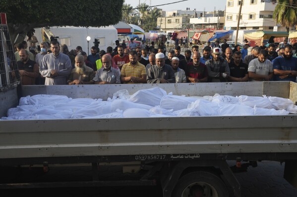 Palestinians pray by the bodies of people killed in the Israeli bombardment in Deir Al-Balah, Gaza Strip, Monday, Oct. 23, 2023. (AP Photo/Adel Hana)