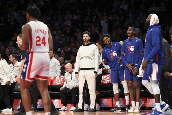 The Philadelphia 76ers bench interacts with Brooklyn Nets guard Cam Thomas (24) during the second half of an NBA basketball game, Sunday, April 9, 2023 in New York. (AP Photo/Jessie Alcheh)