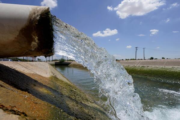 FILE - Water from the Colorado River diverted through the Central Arizona Project fills an irrigation canal, Aug. 18, 2022, in Maricopa, Ariz. Arizona will not approve new housing construction on the fast-growing edges of metro Phoenix that rely on groundwater thanks to years of overuse and a multi-decade drought that is dwindling its water supply. In a news conference Thursday, June 1, 2023, Gov. Katie Hobbs announced the pause on new construction that would affect some of the fastest-growing areas of the nation's 5th largest city. (AP Photo/Matt York, File)