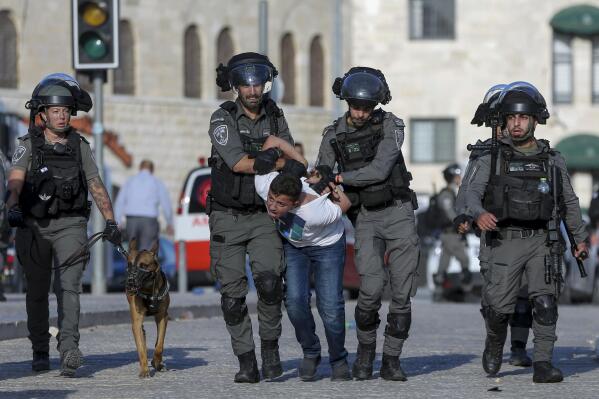 Israeli border police officers detain a Palestinian youth during clashes between Palestinians and Israeli police as thousands of Muslims flocked to Jerusalem's Old City to celebrate the Muslim Prophet Muhammad's birthday, Tuesday, Oct. 19, 2021. (AP Photo/Mahmoud Illean)