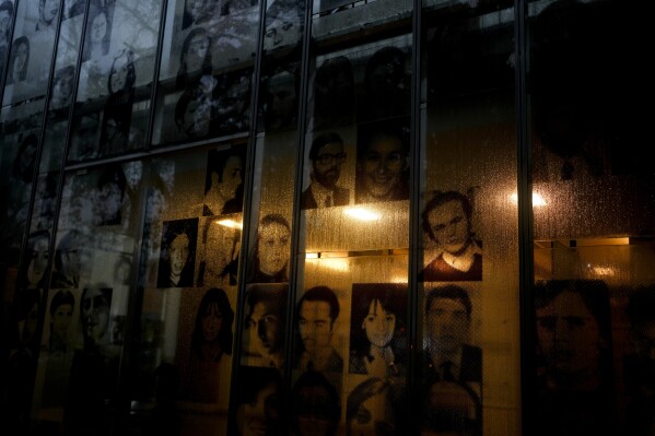 Fotografías de desaparecidos durante la dictadura de Argentina (1976-1983) colgadas en la ventana de la antigua Escuela de Mecánica de la Armada argentina, ahora el museo de Derechos Humanos, en Buenos Aires, Argentina, el jueves 17 de agosto de 2023. Las Abuelas de la Plaza de Mayo estiman que cerca de 500 niños fueron robados de sus padres durante la dictadura y la organización ha identificado hasta ahora a 133 nietos a través de análisis genéticos. (AP Foto/Natacha Pisarenko)