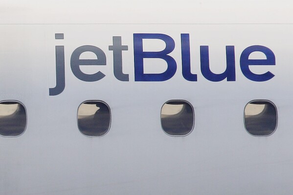FILE - In this Jan. 20, 2011, file photo, a JetBlue logo is displayed on the side of a jet as it taxis at Boston's Logan International Airport. Federal investigators are describing a close call between planes at a Colorado airport last year. The National Transportation Safety Board said Wednesday, Dec. 13, 2023 that a JetBlue plane struck its tail on the ground because the captain took off quickly to avoid a plane that was preparing to land on the same runway. (AP Photo/Stephan Savoia, File)