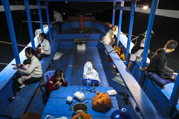 Members of the Tran family fish off Hon Tam Island on Feb. 7, 2025, in Nha Trang, Vietnam. (AP Photo/Yannick Peterhans)