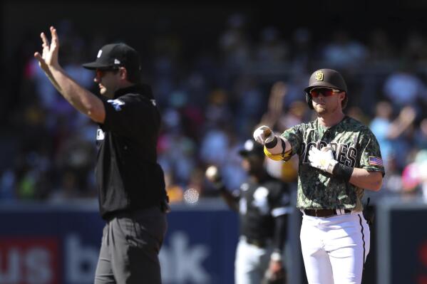 San Diego Padres' Jake Cronenworth, right, points toward the dugout after hitting a double against the Chicago White Sox as umpire Adam Beck calls time in the fourth inning a baseball game Sunday, Oct. 2, 2022, in San Diego. (AP Photo/Derrick Tuskan)