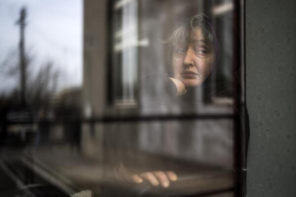A woman who fled a nearby village looks out from a window of a church in Bashtanka, Mykolaiv district, Ukraine, on Thursday, March 31, 2022. (AP Photo/Petros Giannakouris)
