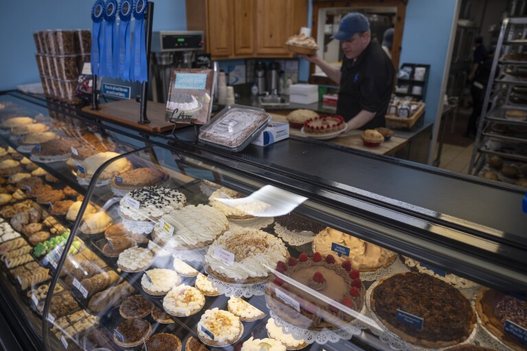 Manager Stephen Jarrett prepares pies at a counter at Michele's Pies, Wednesday, March 13, 2024, in Norwalk, Conn. (AP Photo/John Minchillo)