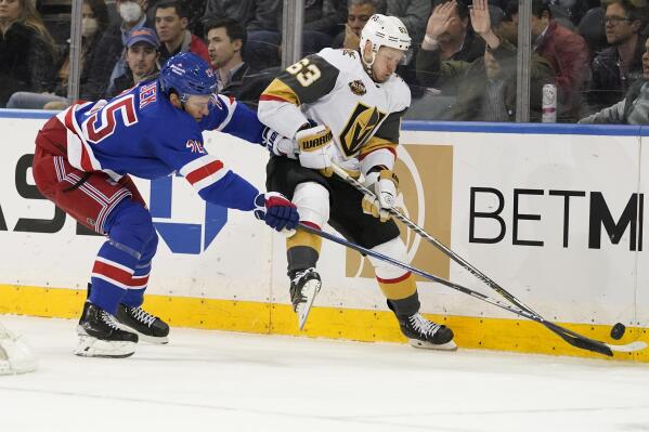 New York Rangers defenseman Libor Hajek (25) and Vegas Golden Knights right wing Evgenii Dadonov (63) fight for the puck during the second period of an NHL hockey game, Friday, Dec. 17, 2021, at Madison Square Garden in New York. (AP Photo/Mary Altaffer)