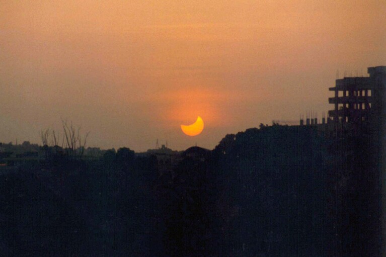 FILE - The sun sets over Hyderabad, India during the last phases of the last total solar eclipse of the millennium Wednesday, Aug. 11, 1999. (AP Photo/P Anil Kumar, File)