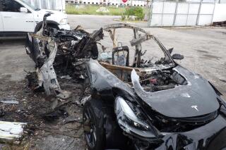 FILE - This image provided by the National Transportation Safety Board shows damage to a 2021 Tesla Model 3 Long Range Dual Motor electric car following a crash in September, 2021, in Coral Gables, Fla.  A Florida jury on Tuesday, July 19, 2022,  found electric car maker Tesla negligent for disabling a speed limiter on a vehicle but placed much of the blame for a fiery fatal crash on the 18-year-old driver.  Barrett Riley and his friend Edgar Monserrat Martinez, both seniors at a private school in South florida, died in the May 2018 crash in Fort Lauderdale. A backseat passenger was ejected from the car and survived, officials said.  (NTSB via AP, File)