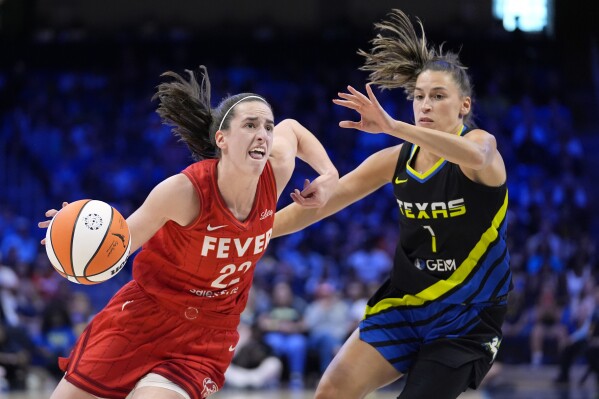 FILE- Indiana Fever guard Caitlin Clark (22) works to the basket against Dallas Wings guard Sevgi Uzun (1) in the first half of a WNBA basketball game Sunday, Sept. 1, 2024, in Arlington, Texas. (AP Photo/Tony Gutierrez, File)