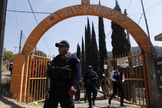 Policías vigilan el sitio de peleas de gallos "El Paraíso" en Zinapécuaro, México, el lunes 28 de marzo de 2022. Veinte personas murieron el día anterior cuando hombres armados irrumpieron en el sitio, según fiscales en el estado occidental de Michoacán. (AP Foto/Armando Solís)