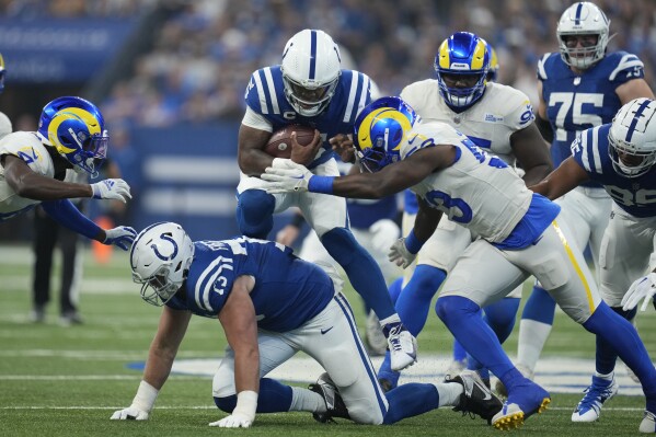 Indianapolis Colts quarterback Anthony Richardson, above center, carries the ball as Los Angeles Rams linebacker Ernest Jones, right, defends during the first half of an NFL football game, Sunday, Oct. 1, 2023, in Indianapolis. (AP Photo/Michael Conroy)