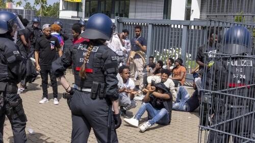 Police officers surrounded a group of people before the start of the Eritrea Festival in Giessen, Germany, Saturday, July 8, 2023. German police say several officers were injured and dozens of people were detained Saturday during unrest at an Eritrean cultural event in the western city of Giessen. Authorities had tried to ban the festival after similar unrest occurred there last year, but a court overturned the order. (Helmut Fricke/dpa via AP)