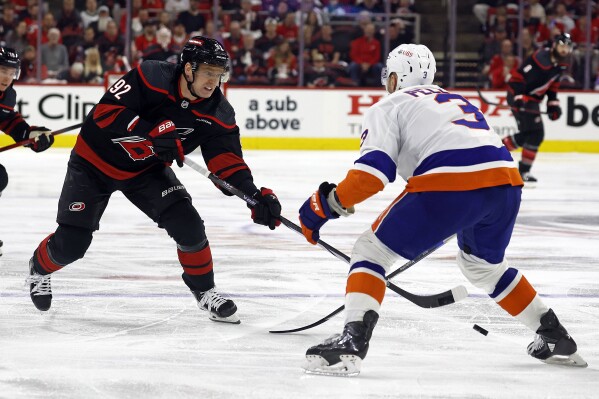 Carolina Hurricanes' Evgeny Kuznetsov (92) moves the puck past New York Islanders' Adam Pelech (3) during the second period in Game 1 of an NHL hockey Stanley Cup first-round playoff series in Raleigh, N.C., Saturday, April 20, 2024. (AP Photo/Karl B DeBlaker)