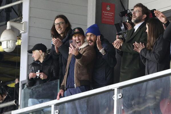 Wrexham owners Ryan Reynolds, center left, and Rob McElhenney, center right, react during the National League match between Wrexham and Notts County at the Racecourse Ground, Wrexham, Wales, Monday April 10, 2023. (Barrington Coombs/PA via AP)