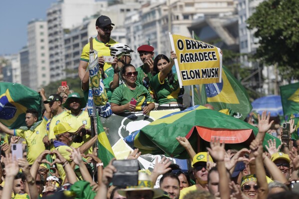 A supporter of Brazil's former President Jair Bolsonaro holds a sign that reads in Portuguese "Brazil thanks, Elon Musk" during a demonstration calling for freedom of expression, spurred by Brazilian court orders to suspend accounts on the social media platform X, in Copacabana beach, in Rio de Janeiro, Brazil, Sunday, April 21, 2024. (AP Photo/Bruna Prado)
