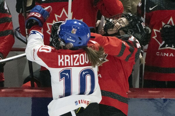 Czechia's Denisa Krizova (10) checks Canada's Renata Fast (14) by the boards doing the first period of a hockey match at the Women's World Championships in Utica, N.Y., Sunday, April 7, 2024. Canada beat Czechia 5-0.(Christinne Muschi/The Canadian Press via AP)