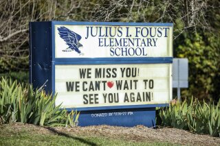 FILE - This Friday, Oct. 23, 2020 file photo shows a sign for the Julius I. Foust Elementary School in Greensboro, N.C. A report from the state's Department of Public Instruction released in December 2020, estimates the whereabouts of less than 1% of the roughly 1.5 million students in the state system is unknown. (Abby Gibbs/News & Record via AP)