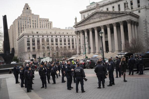 New York Police officers wait for instructions around the courthouse ahead of former President Donald Trump's anticipated indictment on Wednesday, March 22, 2023, in New York. A New York grand jury investigating Trump over a hush money payment to a porn star appears poised to complete its work soon as law enforcement officials make preparations for possible unrest in the event of an indictment. (AP Photo/Eduardo Munoz Alvarez)