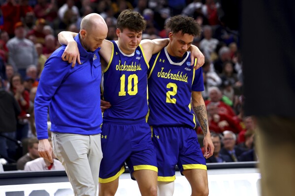 South Dakota State's Kalen Garry (10) is helped off the court after being injured during the second half of a first-round college basketball game against Iowa State in the NCAA Tournament Thursday, March 21, 2024, in Omaha, Neb. (AP Photo/John Peterson)
