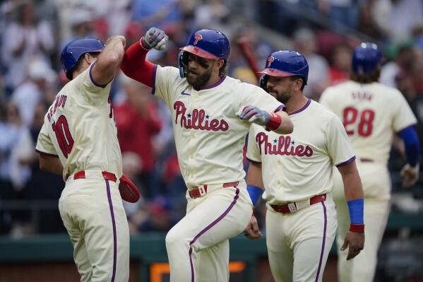 Philadelphia Phillies' Bryce Harper, second from left, celebrates with J.T. Realmuto, left, and Kyle Schwarber, front right, after hitting a three-run home run off San Francisco Giants pitcher Mason Black during the fifth inning of a baseball game, Monday, May 6, 2024, in Philadelphia. (AP Photo/Matt Rourke)