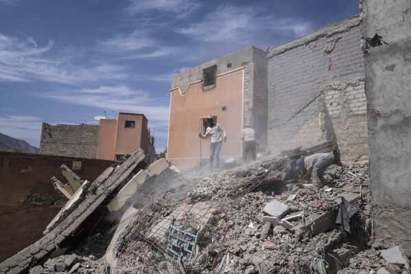 FILE - People dig through the rubble as they try to salvage usable belongings and equipments, in Amizmiz, outside Marrakech, Friday, Oct. 6, 2023. Hundreds of protesters on Tuesday, Oct. 24, took to the streets of Amizmiz near the epicenter of a devastating earthquake that hit Morocco last month to express anger and frustration after weeks of waiting for emergency assistance. (AP Photo/Mosa'ab Elshamy, File)