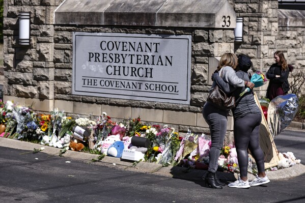 FILE - Two women hug at a memorial at the entrance to The Covenant School on Wednesday, March 29, 2023, in Nashville, Tenn. Tennessee Gov. Bill Lee on Tuesday, Aug. 8, 2023 unveiled a sweeping list of public safety issues he wants lawmakers to address during an upcoming special session prompted by a shocking Nashville school shooting earlier this year that resulted in the deaths of three children and three adults. (AP Photo/Wade Payne, File)