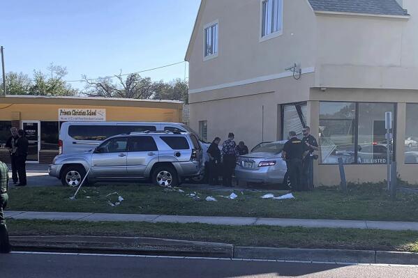 Law enforcement investigators examine a vehicle after it crashed into the side of a building in Winter Haven, Fla. Monday, Feb. 6, 2023. A man suspected in a mass shooting in central Florida last month was fatally shot by a police officer following a long chase and a carjacking, authorities said. The car driven by Alex Greene, 21, eventually crashed into a business in Winter Haven. (Sara Megan Walsh/The Ledger via AP)