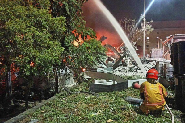 In this image provided by the Pingtung County Government, a firefighter tries to extinguish a fire at a factory of golf ball manufacturer Launch Technologies Co. in the southern county of Pingtung in Taiwan on Friday, Sept. 22, 2023. The factory fire has left multiple people killed, and the victims include several firefighters, according to Taiwanese media reports. (Pingtung County Government via AP)