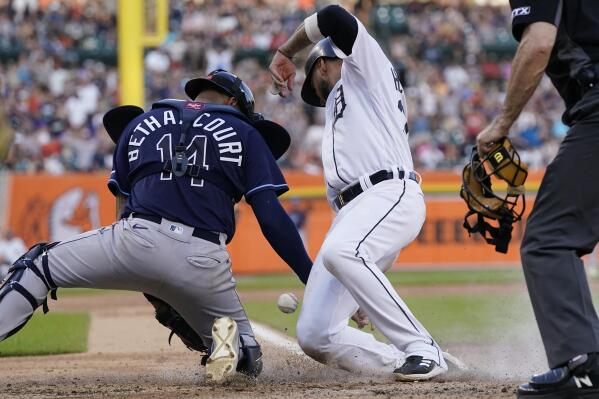 Tampa Bay Rays catcher Christian Bethancourt bobbles the throw from left fielder David Peralta as Detroit Tigers' Willi Castro scores during the fifth inning of a baseball game, Saturday, Aug. 6, 2022, in Detroit. (AP Photo/Carlos Osorio)