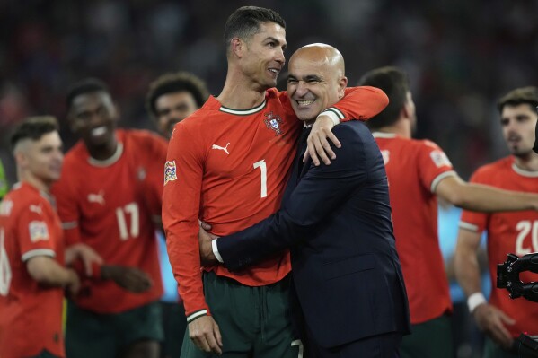Portugal's Cristiano Ronaldo celebrates with Portugal coach Roberto Martinez after the Nations League final soccer match between Portugal and Spain at the Allianz Arena in Munich, Germany, Sunday, June 8, 2025. (AP Photo/Matthias Schrader)