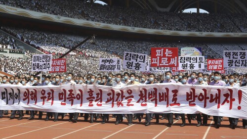 Pyongyang people take part in a demonstration after a mass rally to mark what North Korea calls "the day of struggle against U.S. imperialism" at the May Day Stadium in Pyongyang, North Korea Sunday, June 25, 2023. The signs read "Let us make the U.S. imperialists pay dearly for the blood shed by Korean nation!," "The U.S. is the chieftain of war and massacre," "merciless annihilation," "The U.S is the destroyer of peace," "chieftain of aggression," "blood to blood" and "nuclear war maniac." (AP Photo/Jon Chol Jin)