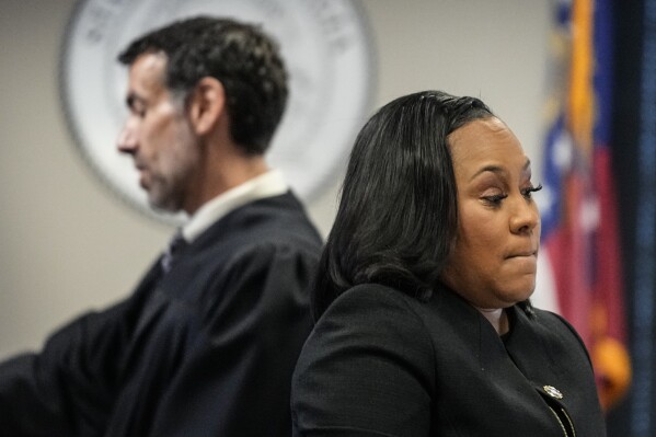 Fulton County District Attorney Fani Willis, right, and Fulton County Superior Court Judge Robert McBurney speak in the Fulton county courthouse, Tuesday, July 11, 2023, in Atlanta. A grand jury being seated Tuesday in Atlanta will likely consider whether criminal charges are appropriate for former President Donald Trump or his Republican allies for their efforts to overturn his 2020 election loss in Georgia. (AP Photo/Brynn Anderson)