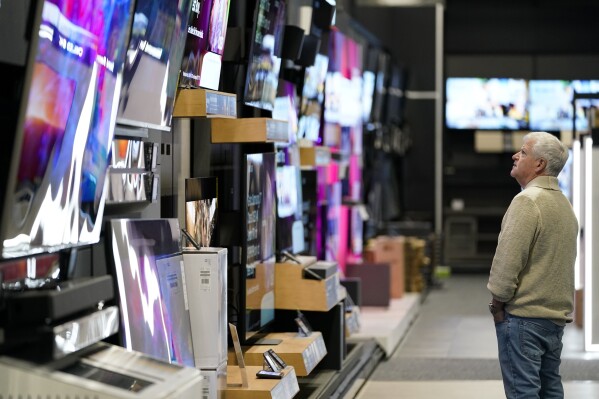 FILE - A customer browses televisions at a Best Buy store on Black Friday, Friday, Nov. 24, 2023, in Charlotte, N.C. Inflation gradually loosened its grip on Wall Street and the economy in 2023, raising hopes for a gentler Federal Reserve and solid gains for the market next year. (AP Photo/Erik Verduzco, File)