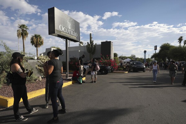 Activists, police and support groups gather outside the Ocotillo Apartments and Hotel in Tucson, Ariz., on Wednesday, Sept. 20, 2023, in anticipation of more than 200 residents being evicted. The site that is supposed to house people being treated for drug and alcohol abuse closed suddenly Wednesday, as Arizona continues to investigate a rehabilitation scheme that targeted Native Americans. (Grace Trejo/Arizona Daily Star via AP)