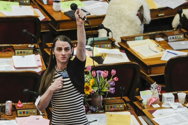 FILE - Montana Rep. Zooey Zephyr, D-Missoula, alone on the House floor, stands in protest as demonstrators are arrested in the House gallery of the state Capitol, April 24, 2023, in Helena, Mont. Republican legislative leaders persisted in forbidding the Democratic transgender lawmaker from participating in debate for a second week as her supporters brought the House session to a halt chanting "Let her speak!" from the gallery. Lewis and Clark County prosecutors in Montana are declining to pursue the misdemeanor trespassing charges filed against the seven protesters who were arrested. (Thom Bridge/Independent Record via AP, File)