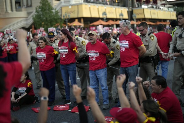 Las Vegas police arrest members of the Culinary Workers Union along the Strip, Wednesday, Oct. 25, 2023, in Las Vegas. Thousands of hotel workers fighting for new union contracts rallied Wednesday night on the Las Vegas Strip, where rush-hour traffic was disrupted when some members blocked the road before being detained by police. (AP Photo/John Locher)