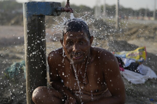 A man bathes at a public water tap near the River Ganges during a hot summer day in Prayagraj, India. Thursday, May 2, 2024. (Ǻ Photo/Rajesh Kumar Singh)
