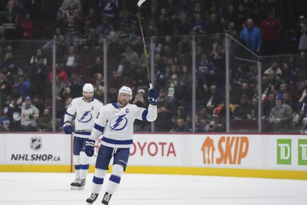 Tampa Bay Lightning's Steven Stamkos raises his stick to the crowd while receiving a standing ovation after he scored against the Vancouver Canucks, his 500th career goal, during the first period of an NHL hockey game Wednesday, Jan. 18, 2023, in Vancouver, British Columbia. (Darryl Dyck/The Canadian Press via AP)