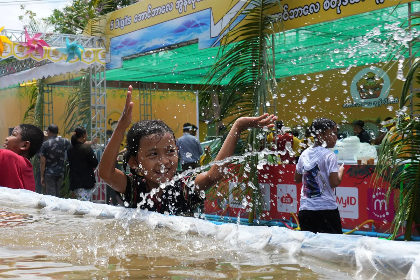Niños con mascarillas juegan con agua durante el Thingyan en Yangon, Myanmar, abril 2025