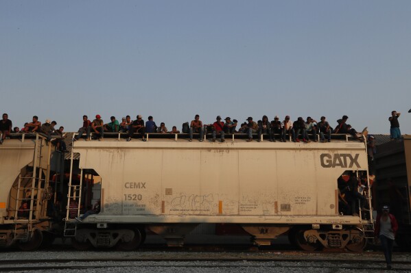 FILE - Central American migrants ride atop a freight train during their journey toward the US-Mexico border, in Ixtepec, Oaxaca State, Mexico, April 23, 2019. Oaxaca is a key route for migrants seeking to cross Mexico to reach the U.S. border, and accidents involving migrants there are common. (AP Photo/Moises Castillo, File)